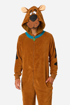 A person wearing a brown Scooby-Doo-themed hooded onesie costume with a blue collar trim and black patch details, photographed against a light gray studio background.