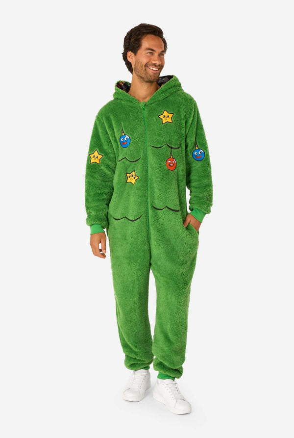 Person wearing a green onesie with colorful patches on a white background