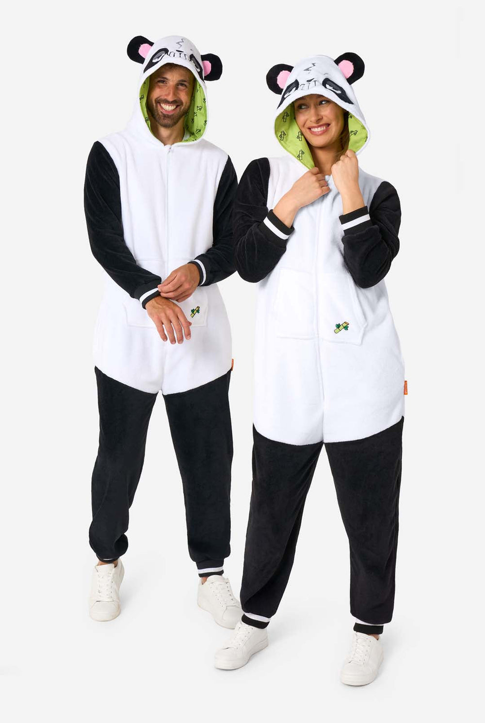Two people wearing panda-themed onesies with a white background