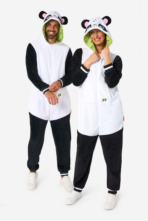 Two people wearing matching white and black panda onesies with bear ears on a white background. Full body image