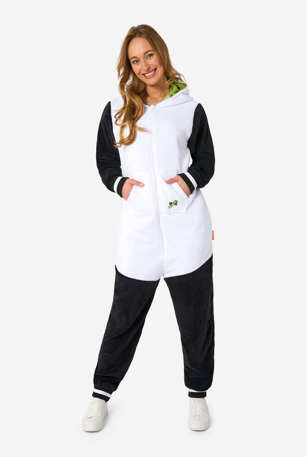 Woman wearing a black and white panda onesie on a white background