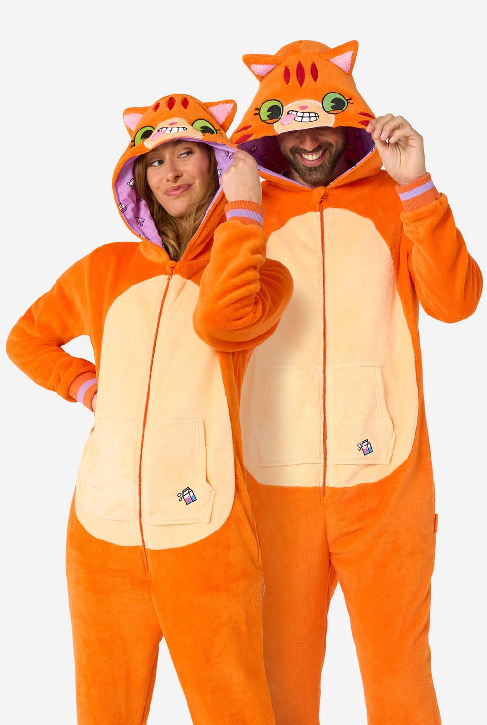 Two people wearing orange cat-themed onesies on a white background