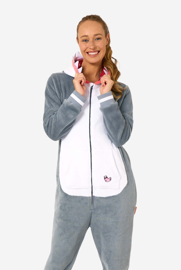 Woman wearing a gray and white shark onesie with a hood on a white background