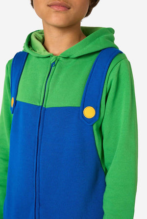 Person wearing a green and blue luigi outfit with a yellow button on a white background, close up