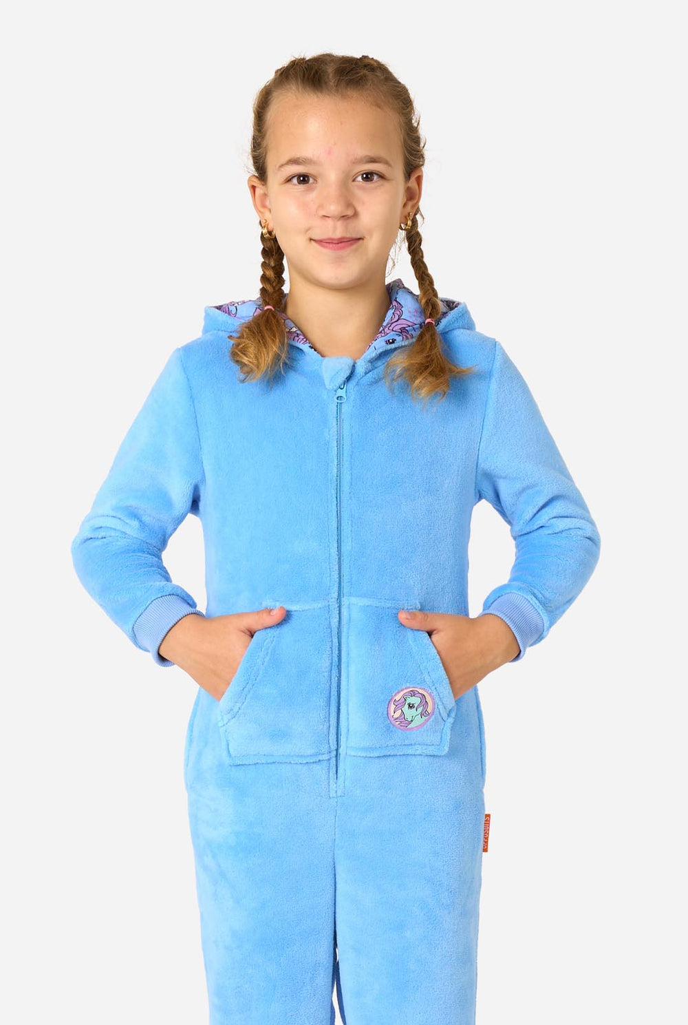 Child wearing a blue My Little Pony onesie with a hood featuring a cartoon character on a white background