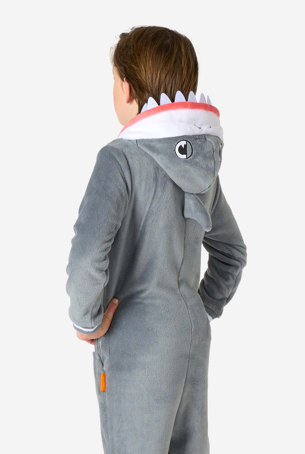 Child wearing a shark-themed onesie with a hood on a white background