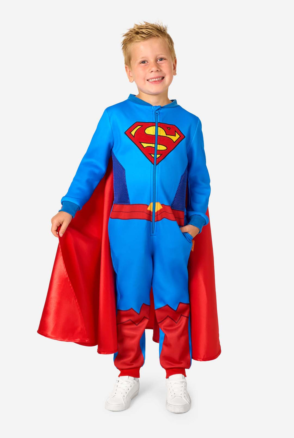 Child wearing a Superman-themed onesie with a red cape on a white background