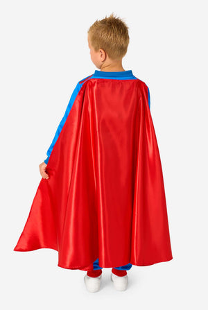 Child wearing a red superhero cape with blue trim on a white background. View from the back