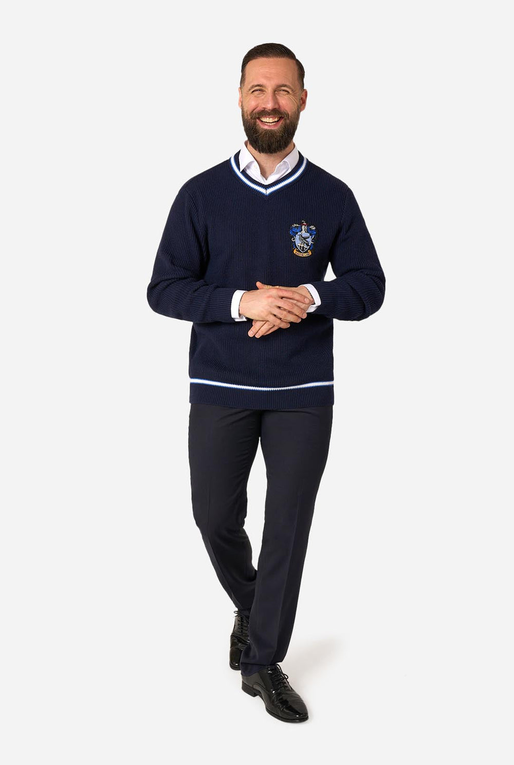 A woman with curly brown hair wearing a navy blue knitted sweater with a Harry Potter Ravenclaw crest on the chest, styled with light blue jeans against a plain white background.