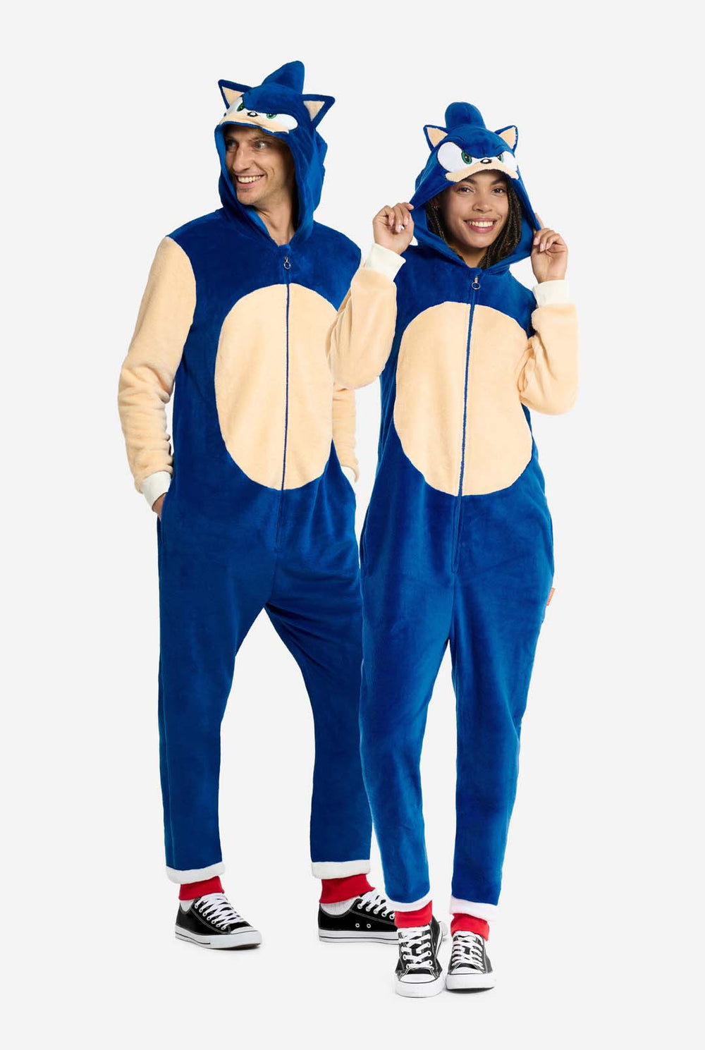 Two people wearing blue and beige onesies with Sonic designs on a white background.
