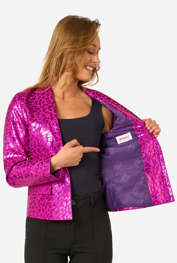 Woman wearing a shiny pink jacket with a purple lining, pointing to the brand logo.