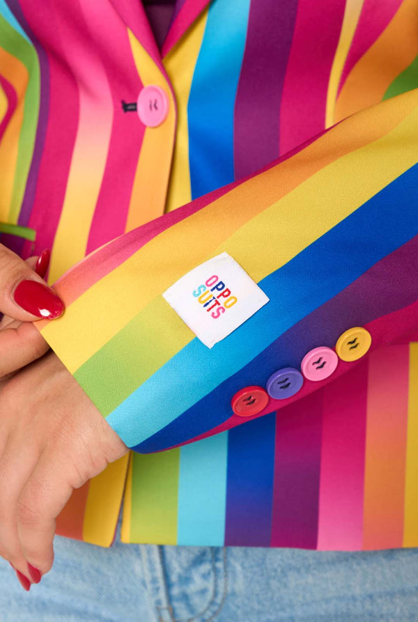 Person holding a colorful sleeve with a brand logo, wearing a multicolored jacket.