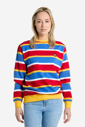 Woman wearing a colorful striped Ernie sweater with a plain background