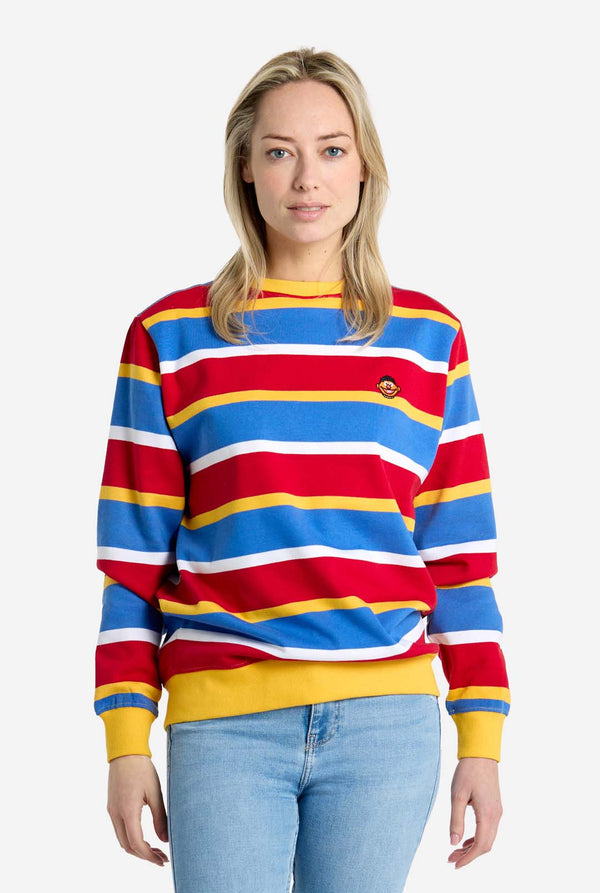 Woman wearing a colorful striped Ernie sweater with a plain background