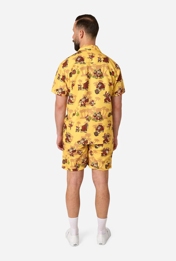 Man wearing a yellow Donkey Kong patterned shirt and shorts on a white background. View from the back.