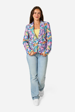 Woman wearing a colorful My Little Pony floral blazer and light blue jeans on a white background. Full body image.