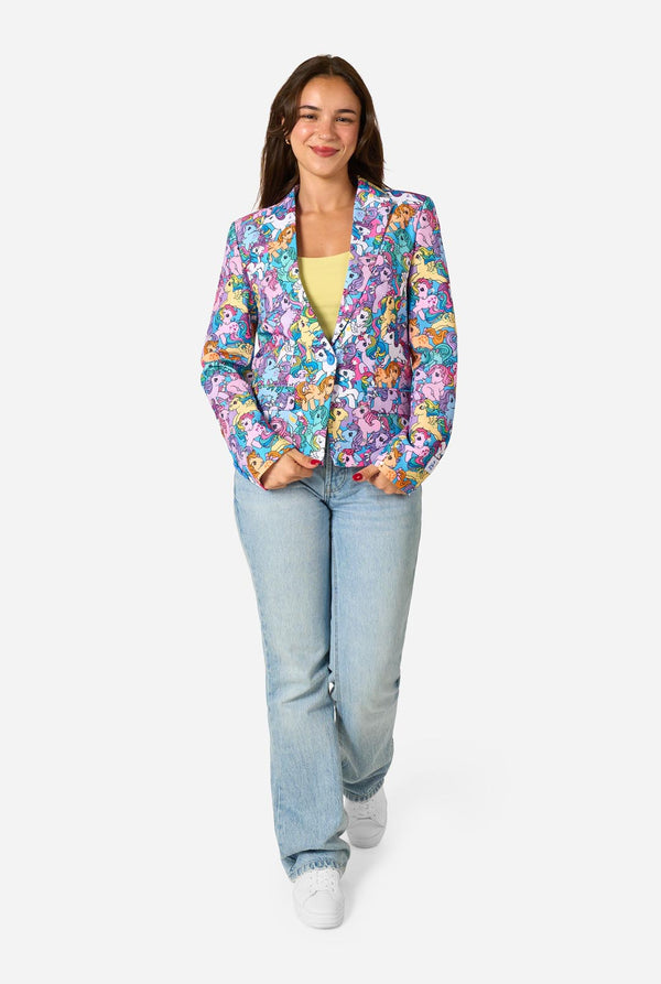 Woman wearing a colorful My Little Pony floral blazer and light blue jeans on a white background. Full body image.