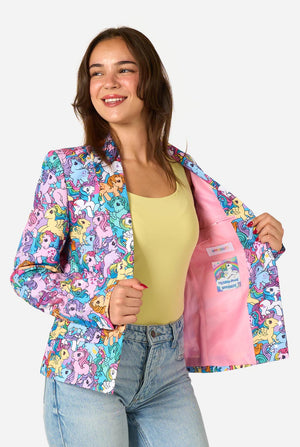 Woman wearing a colorful My Little Pony patterned jacket with cartoon characters, smiling against a white background.