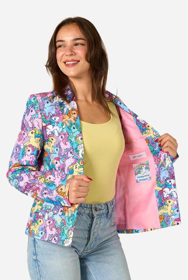 Woman wearing a colorful My Little Pony patterned jacket with cartoon characters, smiling against a white background.