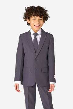 Child wearing a gray suit with a white shirt and tie on a white background