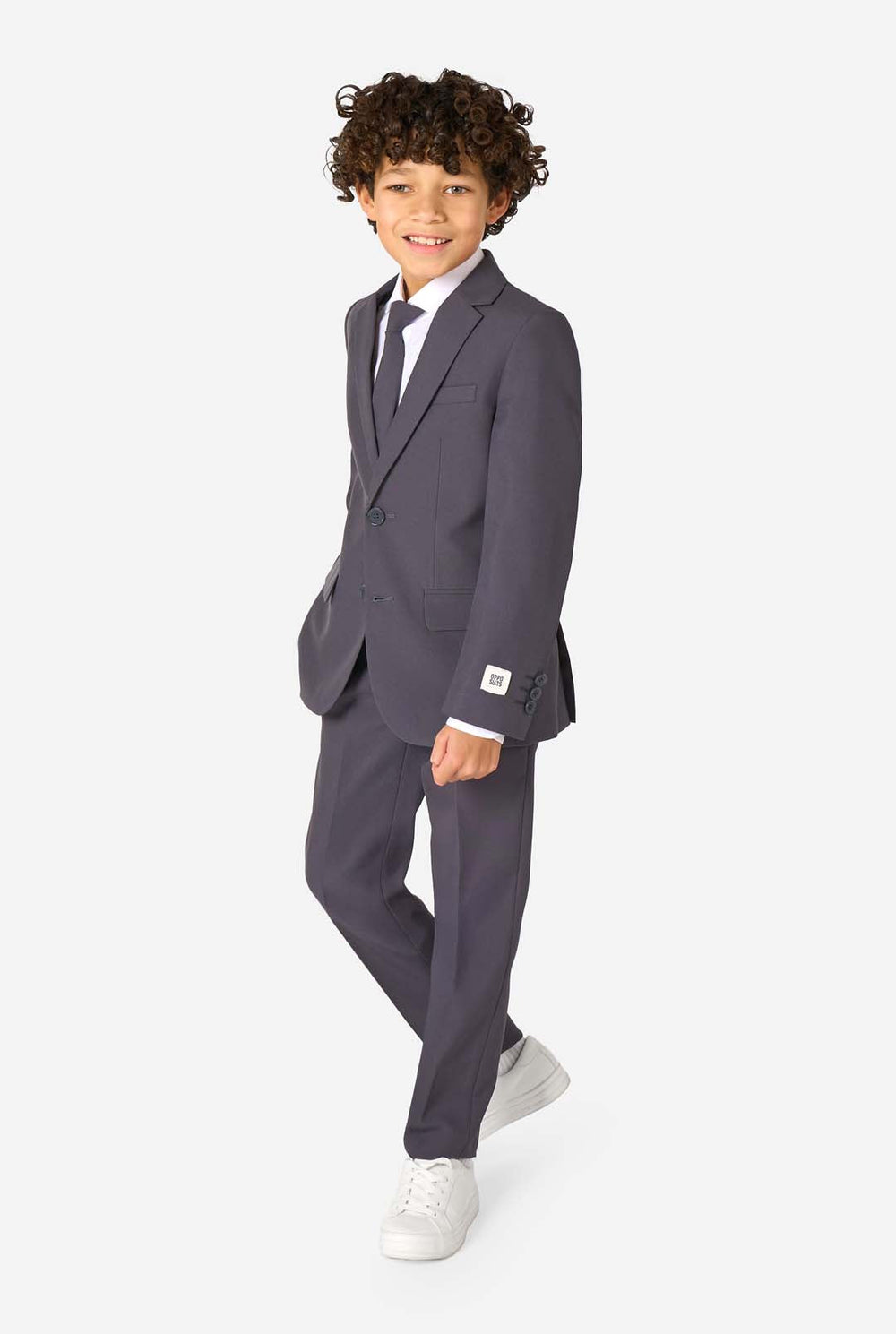 Child wearing a gray suit with a white shirt and tie on a white background