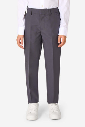 Person wearing gray suit pants with a white shirt and white sneakers on a white background