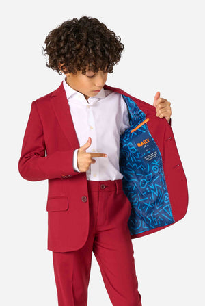 Child in a red suit showing the inside of his jacket with a pattern on a white background