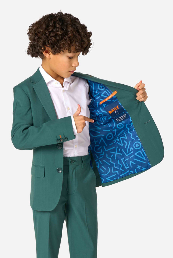 Child wearing a green suit showing the inside of his jacket with a geometric blue pattern on a white background