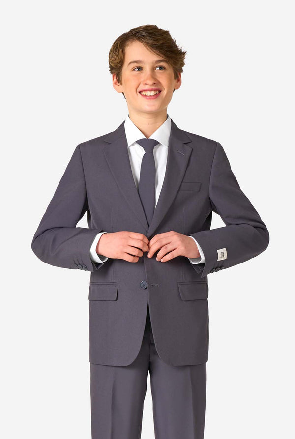 Young boy wearing a gray suit with a white shirt and tie on a white background