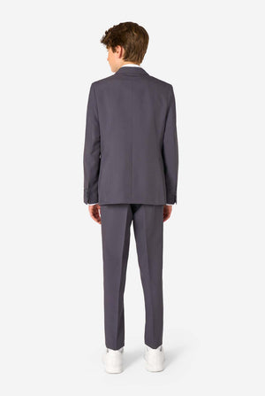 Man wearing a gray suit standing against a white background. View from the back