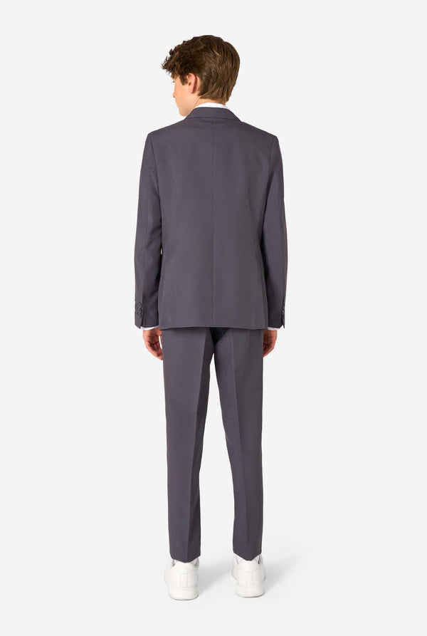 Man wearing a gray suit standing against a white background. View from the back