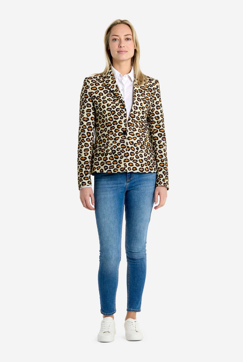 Woman wearing a leopard print blazer and blue jeans on a white background
