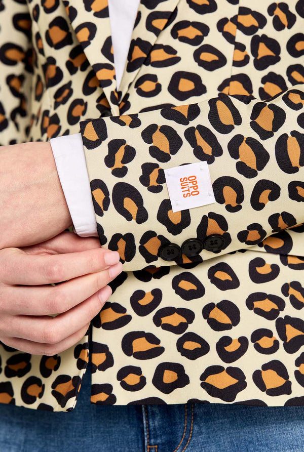 Leopard print fabric with a visible brand label held by a person wearing jeans.
