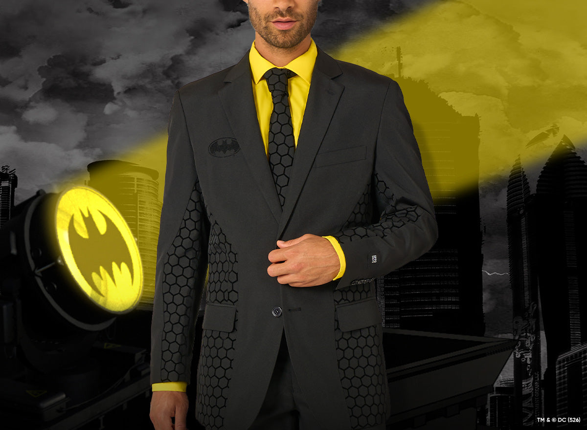 Image with OppoSuits The Batman suit worn by a man. The background resembles Gotham and a spotlight.