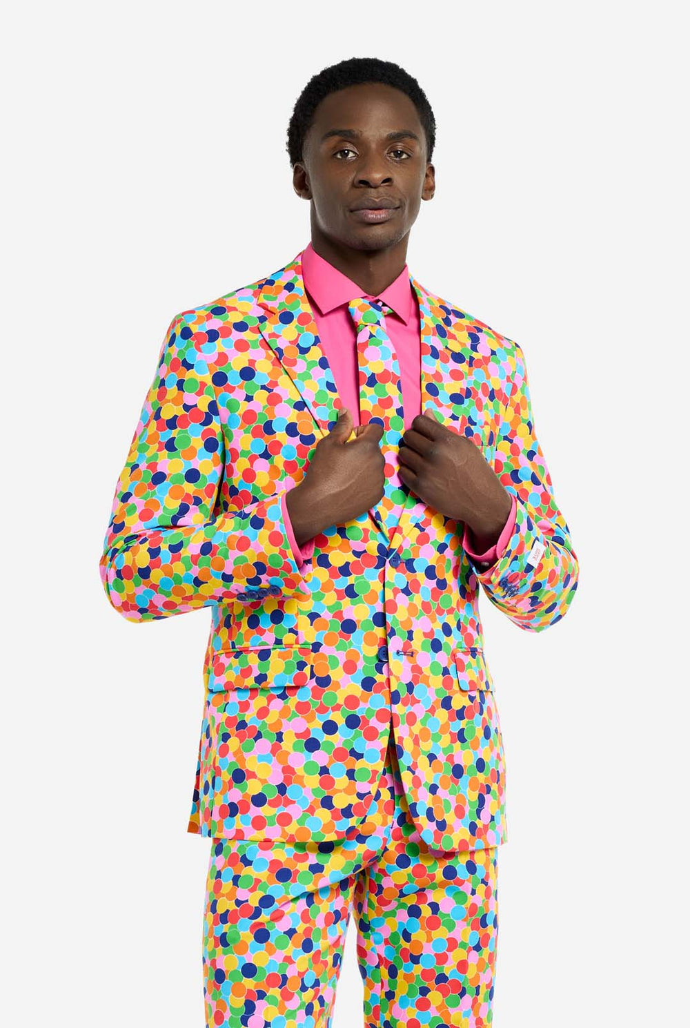 Video of man wearing Confetteroni men's suit with all over confetti print, showing suit like a model. Suit consists of blazer, pant and tie.