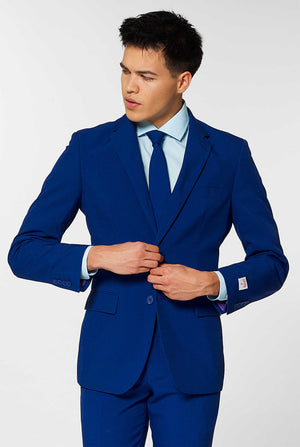 Video of man wearing Navy Royale, dark blue men's suit, showing suit like a model. Suit consists of blazer, pant and tie.