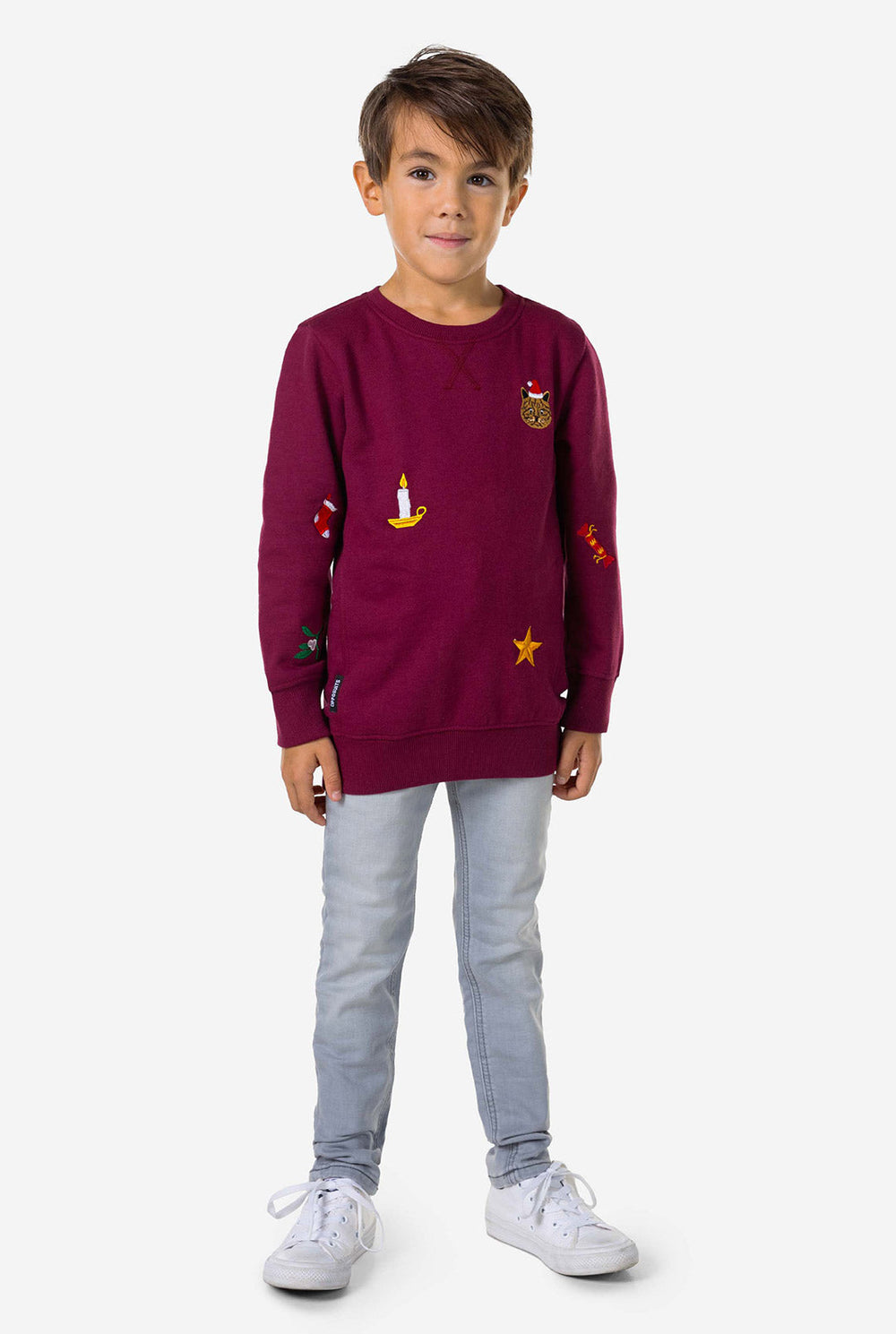 Kid wearing burgundy red Christmas sweater with colored Christmas icons