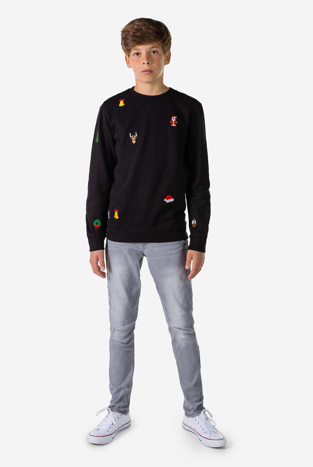Teen wearing black Christmas sweater with Christmas icons