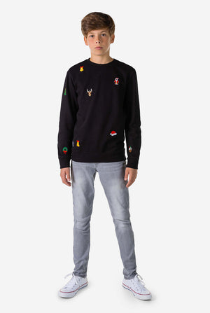 Teen wearing black Christmas sweater with Christmas icons