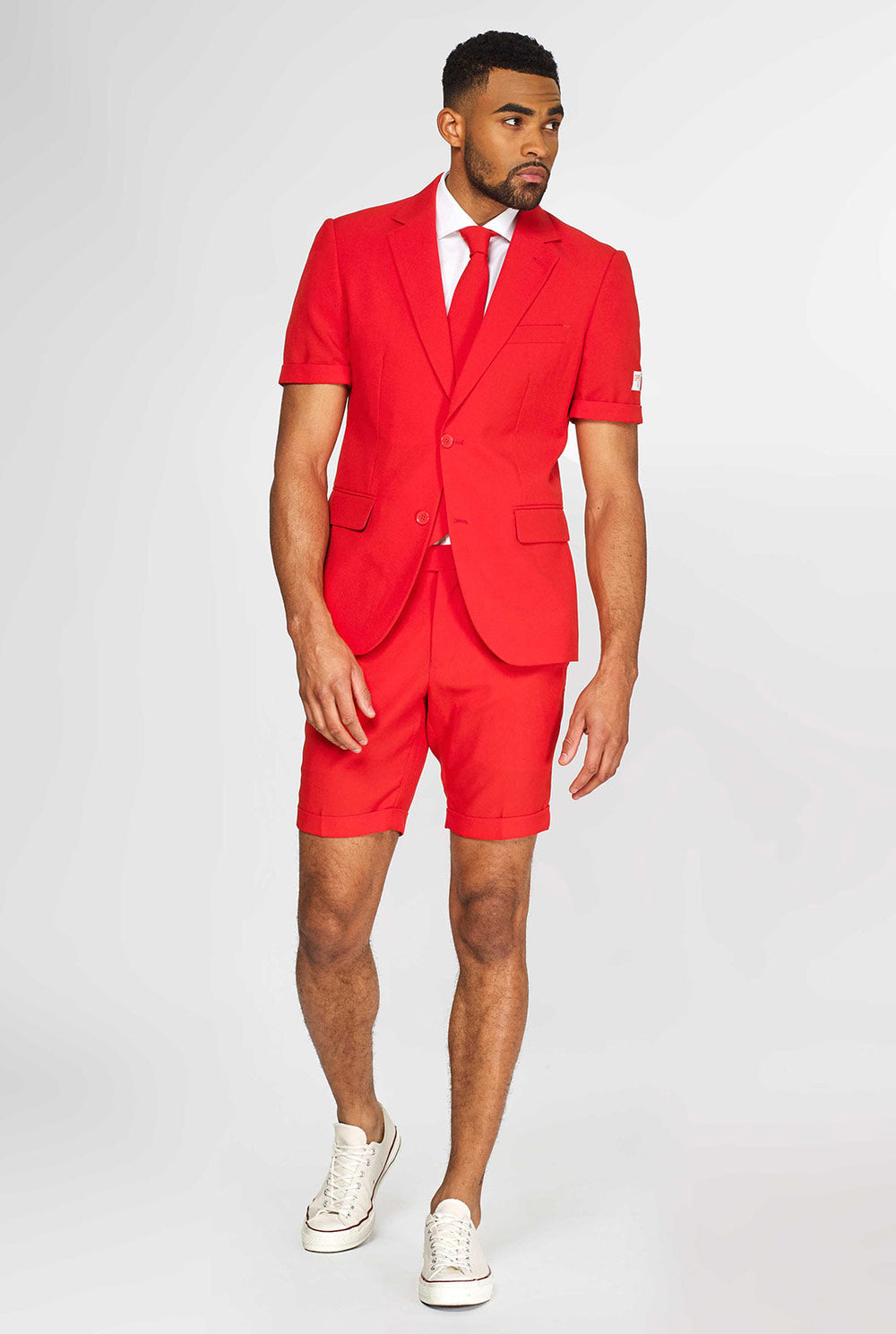 Man wearing red summer suit, consisting of shorts, jacket and tie
