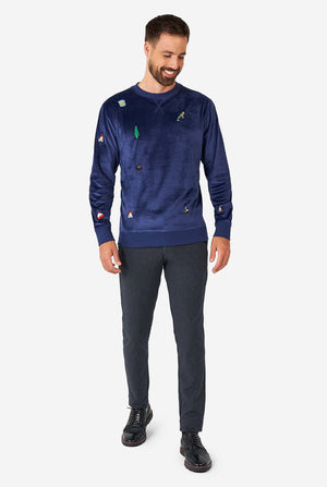 Man wearing velvet blue Christmas sweater with Christmas icons