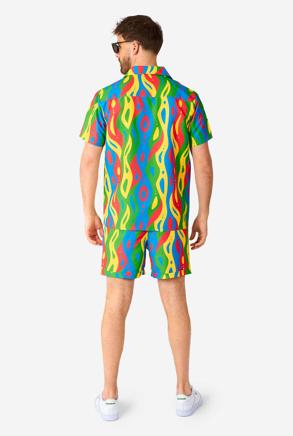 Man wearing colorful summer set, consisting of shirt and shorts.