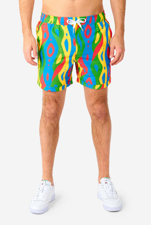 Man wearing colorful summer set, consisting of shirt and shorts.