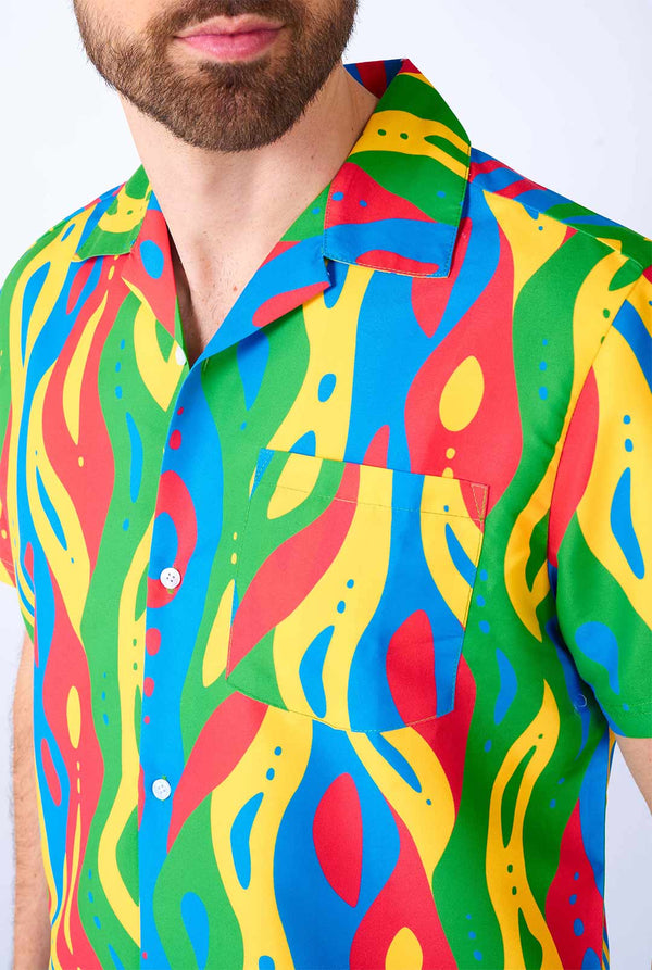 Man wearing colorful summer set, consisting of shirt and shorts.