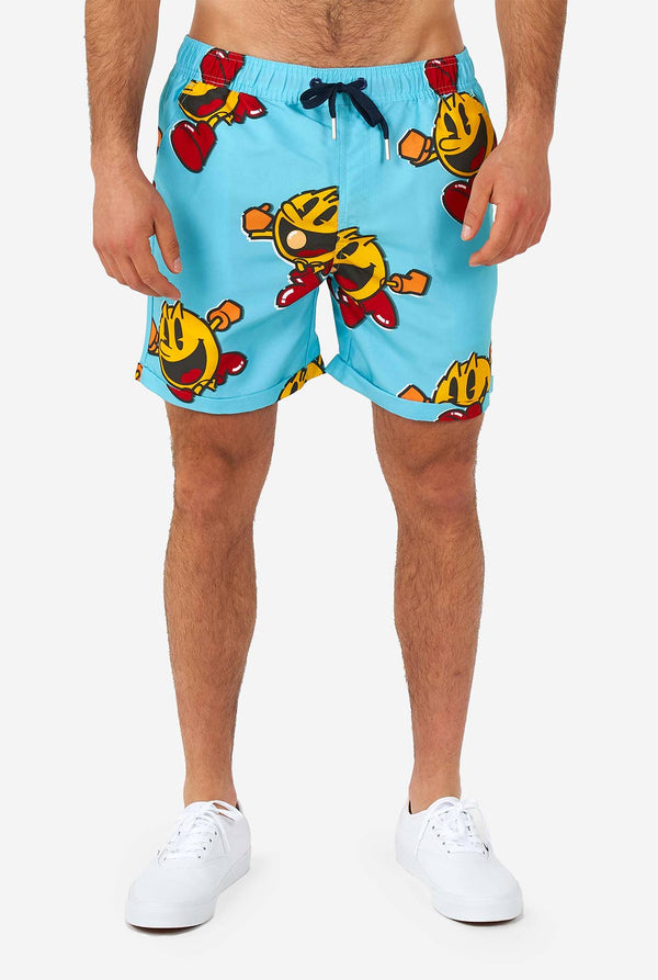 Man wearing blue summer shorts and shirt, with Pac-Man print