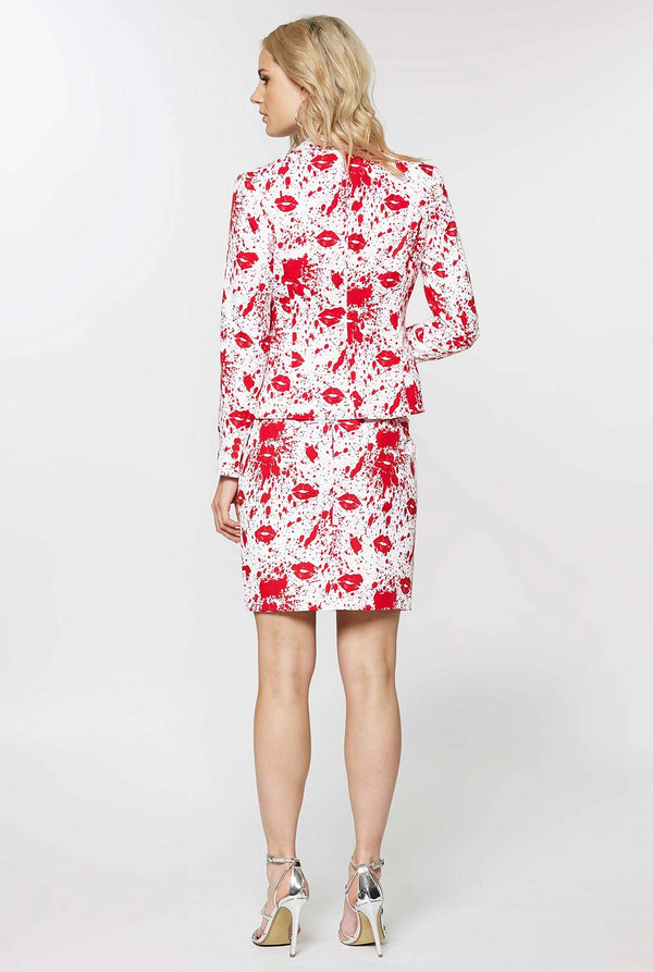 Woman wearing white suit with red blood spatters