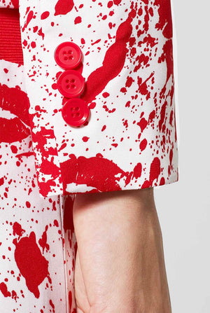Woman wearing white suit with red blood spatters